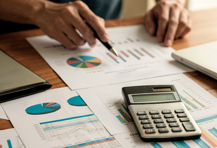 Man Looking At Charts And Graphs On Desk