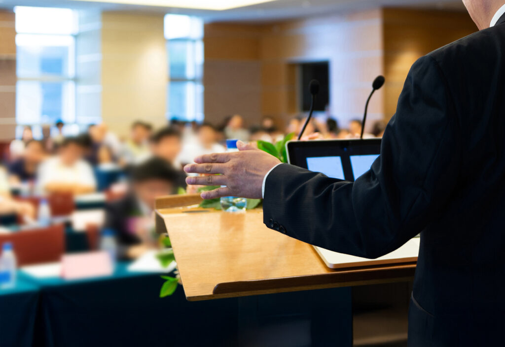 Business Man Making A Speech In Front Of Big Audience