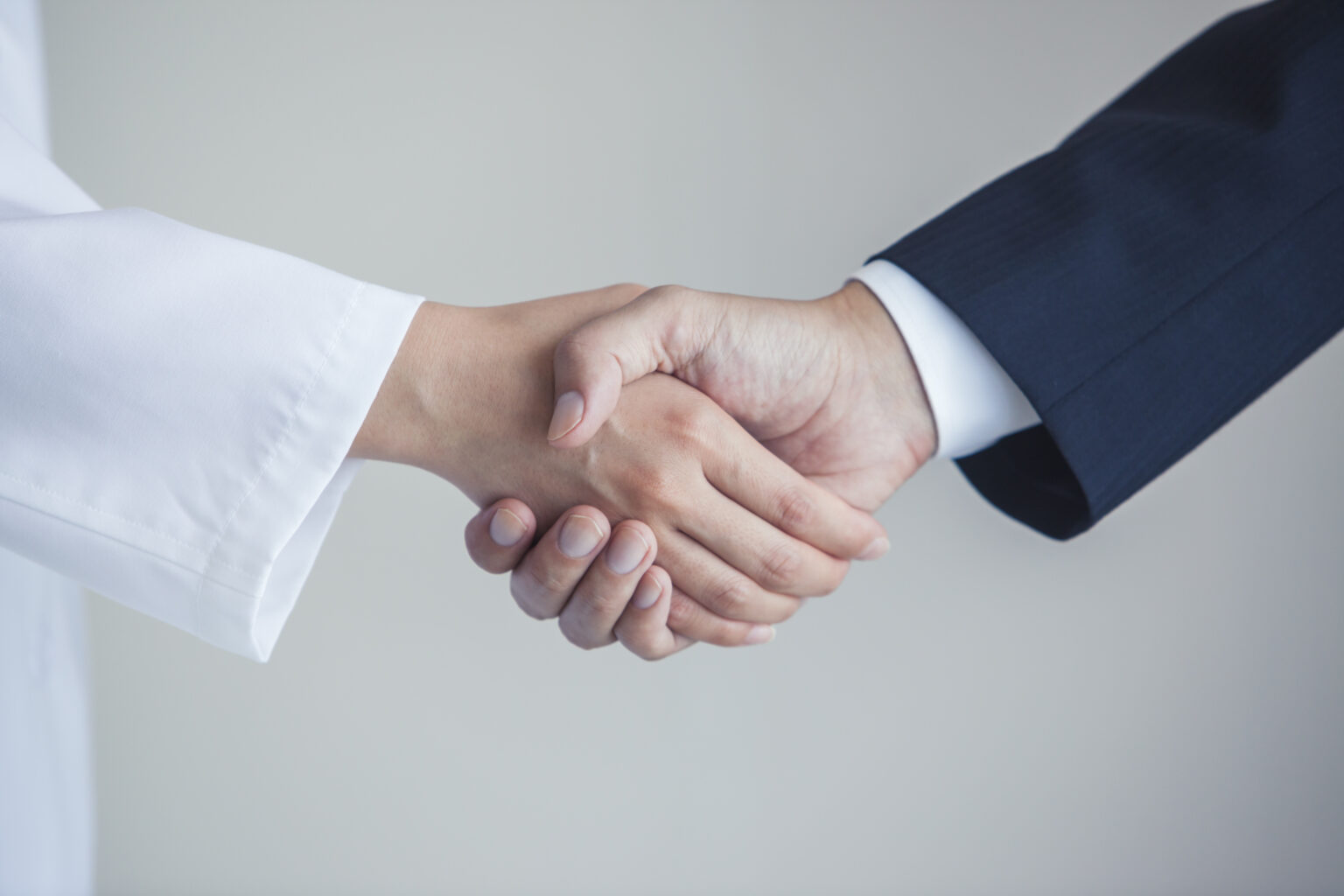 Businessman shaking hands and female doctor at hand